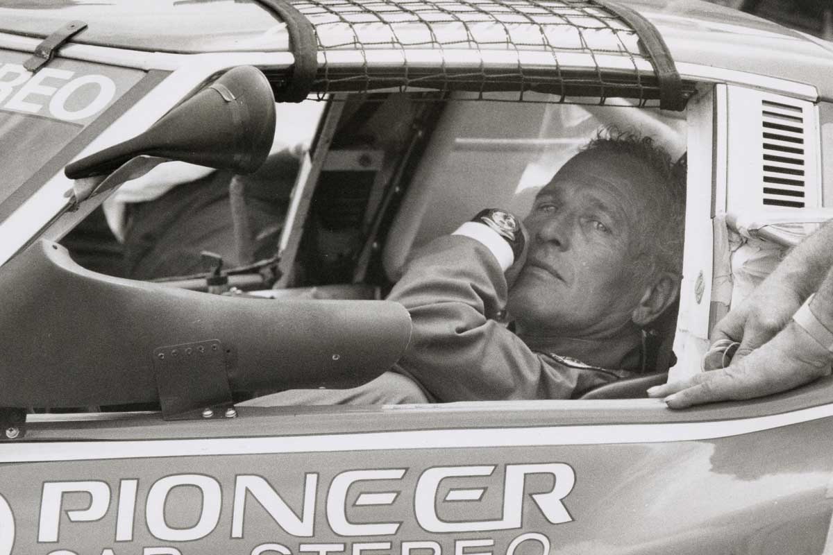 Paul Newman sat in his Datsun, with the unmistakeable 6239 Rolex "Paul Newman" Daytona on his wrist (Image: Ron Galella via Getty Images)