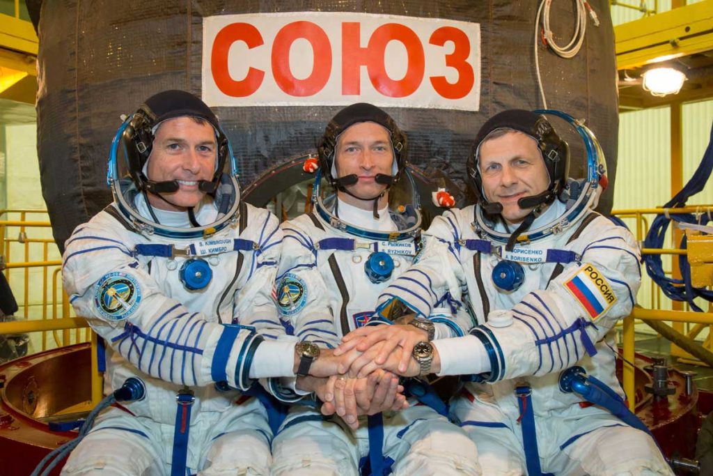 At the Integration Facility at the Baikonur Cosmodrome in Kazakhstan, Expedition 49 crew members Shane Kimbrough of NASA (left) and Sergey Ryzhikov (center) and Andrey Borisenko (right) of Roscosmos pose for pictures Sept. 9 in front of their Soyuz MS-02 spacecraft during a pre-launch training fit check. Kimbrough, Ryzhikov and Borisenko will launch Sept. 24, Kazakh time on the Soyuz MS-02 vehicle for a five-month mission on the International Space Station. Clearly visible on their wrists is their Omega Speedmaster X-33 watches — circa 2016 (Image: NASA/Victor Zelentsov)