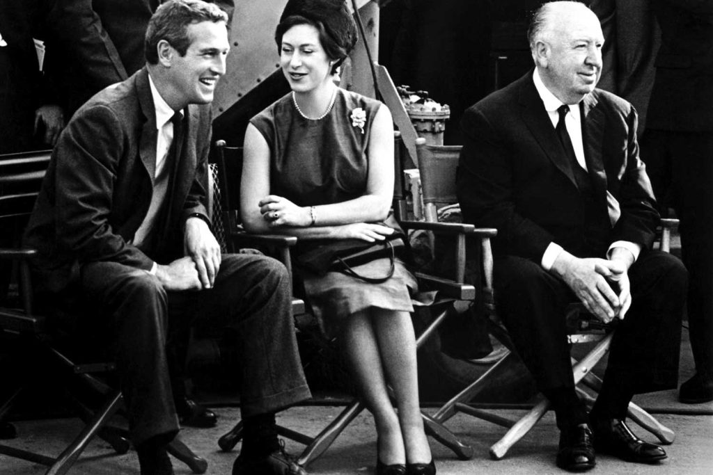No stranger to celebrity, Princess Margaret sits flanked by Paul Newman and Alfred Hitchcock during the filming of Torn Curtain (1966)