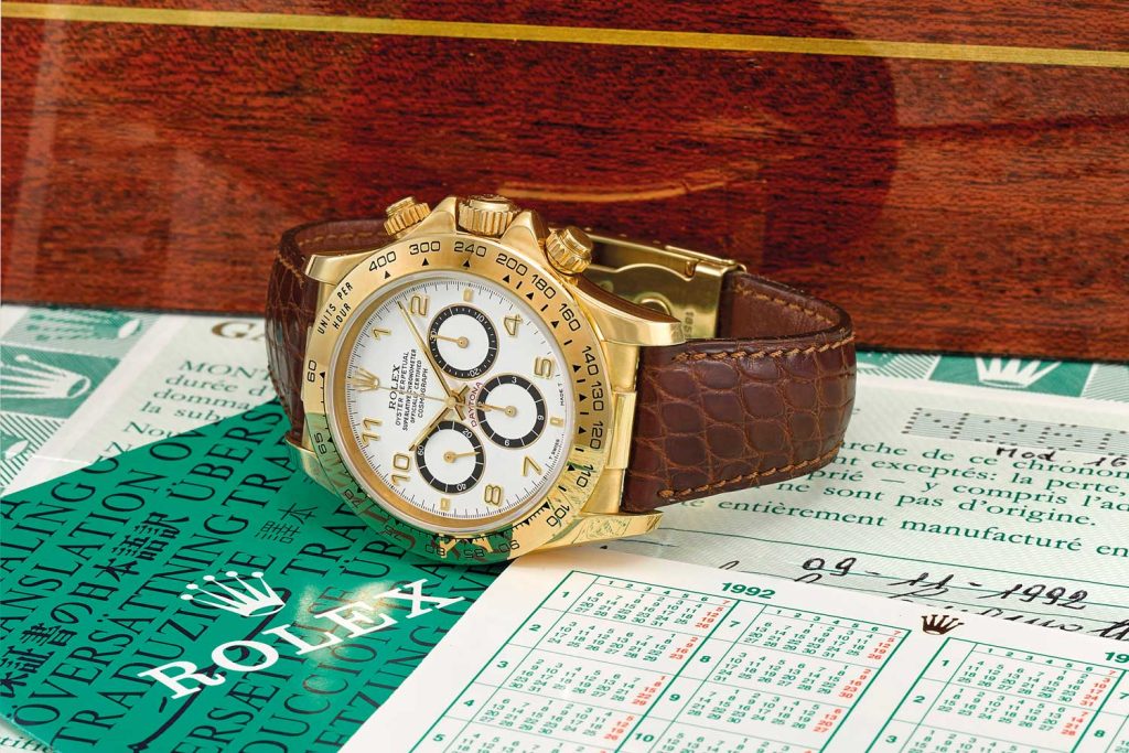 Lot 95: Rolex, a fine 18k gold automatic chronograph wristwatch with original guarantee and box