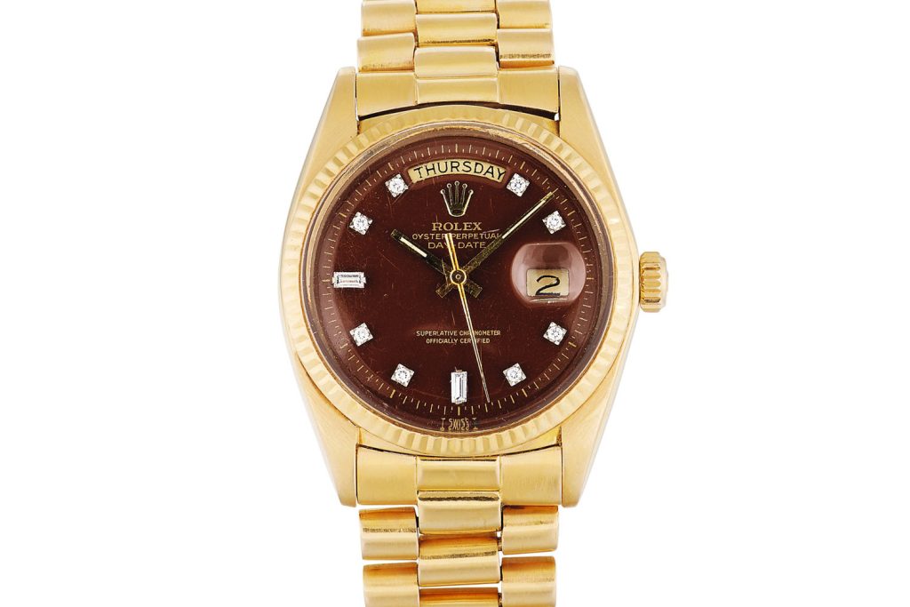 Lot 387: Rolex 'Stella' Day-Date Ref. 1803. Pink gold and diamond-set wristwatch with day, date and burgundy Stella dial, circa 1973