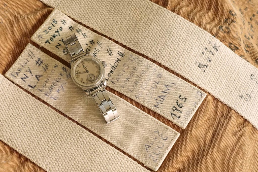 Steel waterproof Longines ”Tre Tacche” ref. 3864, with silvered dial and luminous Arabic numerals, cal. 12.68Z, 1942. Canvas travel bag with the Alessandro’s travel dates around the world