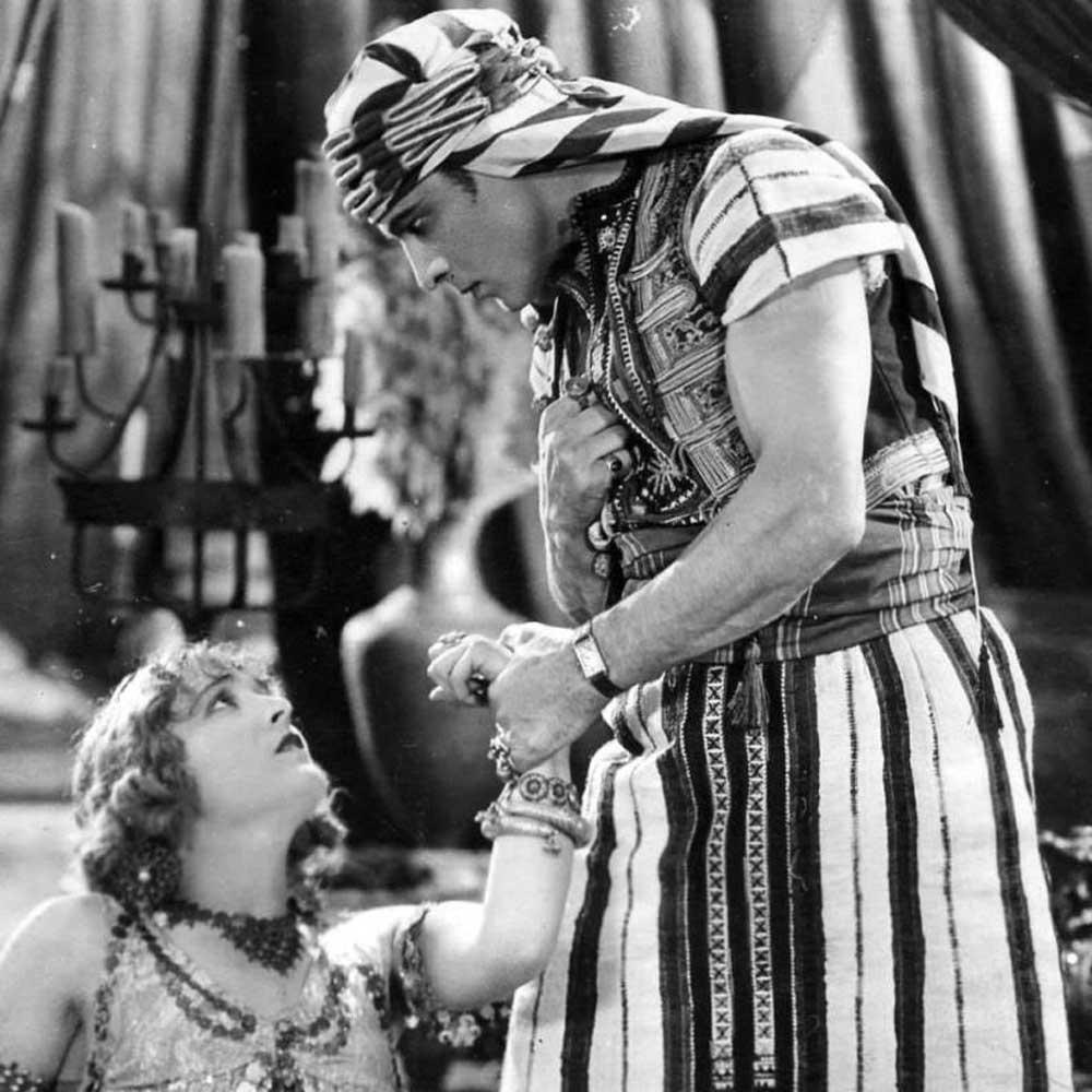 Vilma Banky and Rudolph Valentino in the 1926 film, Son of the Sheik; Valentino insisted on wearing his treasured Cartier Tank during the filming. In every scene. The issue with his decision is that the Tank is not a timepiece that would've been a reality in the period in which the film is based