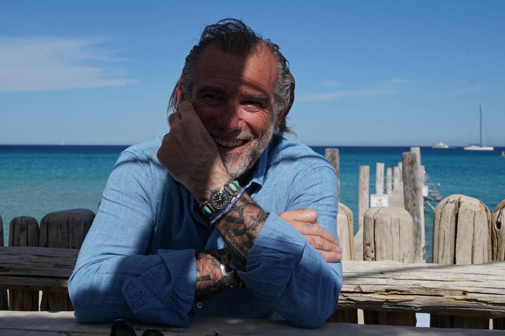 Alessandro Squarzi at Club 55, St. Tropez, wearing a military Elgin wristwatch, 1945, with silver and turquoise Navajo bangle. Vintage chambray shirt
