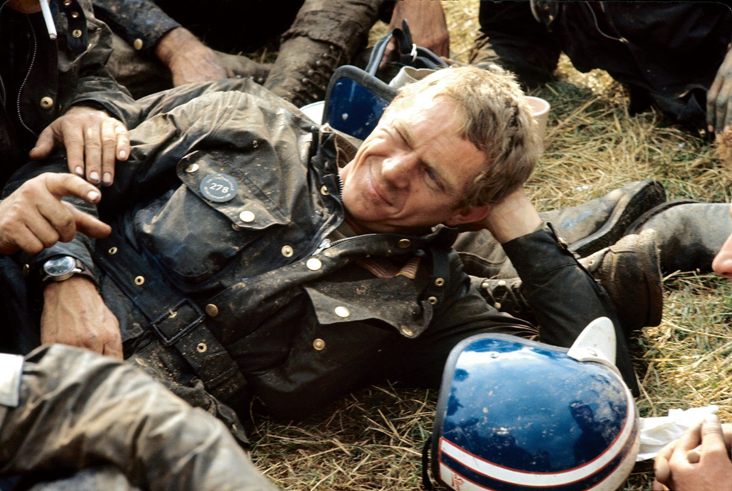 Steve McQueen resting after his run out on the 1964 ISDT track. Each evening after the race (300km on average, on terrible paths), the runners used to collapse on the grass, covered in mud and oil. On his wrist visible is the Hanhart 417 ES (Photo by Francois Gragnon / Paris Match via Getty Images)