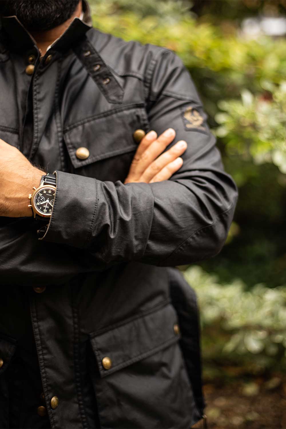 The Hanhart x The Rake & Revolution Limited Edition Bronze 417 Chronograph seen here paired with our exclusive faded vintage black Belstaff jacket completed by its brass snaps and zipper (©Revolution)