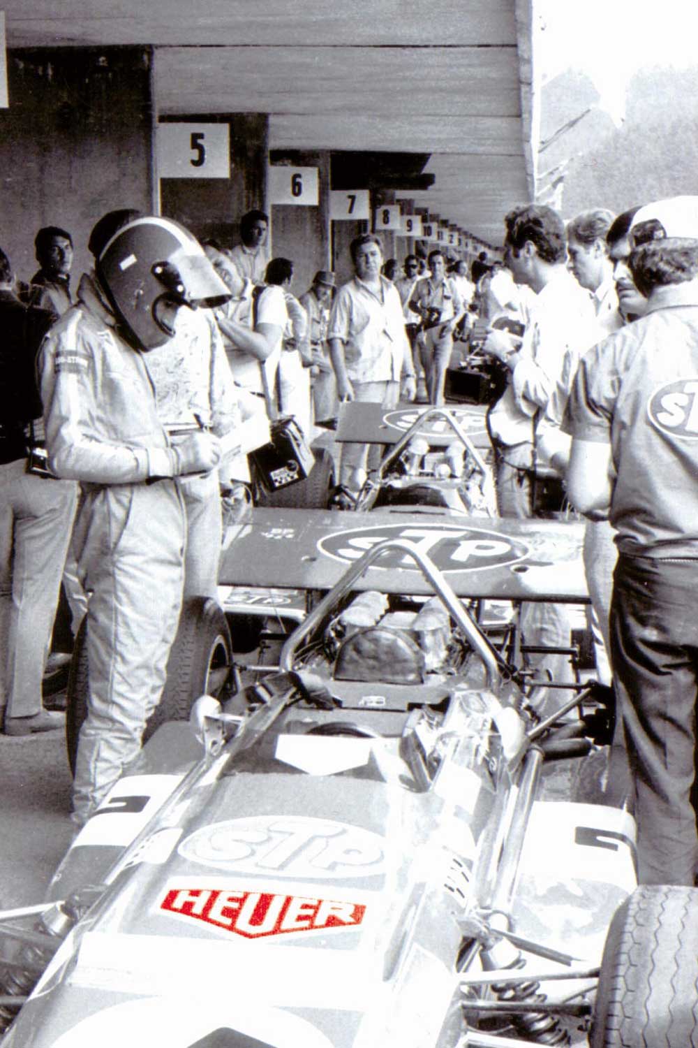Jo Siffert getting ready for a race, with Heuer logos on his suit and car