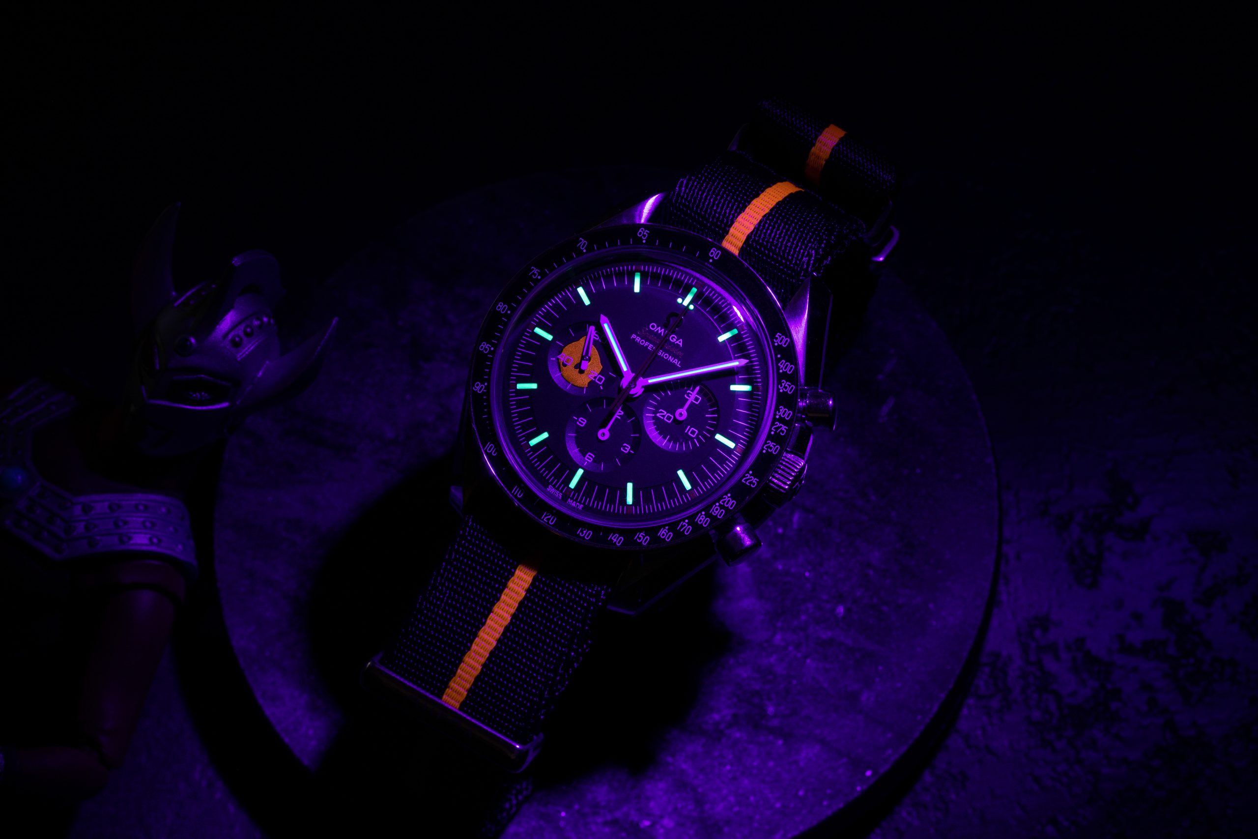The hidden luminous Ultraman silhouette painted inside the continuous seconds marker can be seen only when a UV light used on the 2018 Speedmaster Limited Edition 42mm "Ultraman" , while in the dark