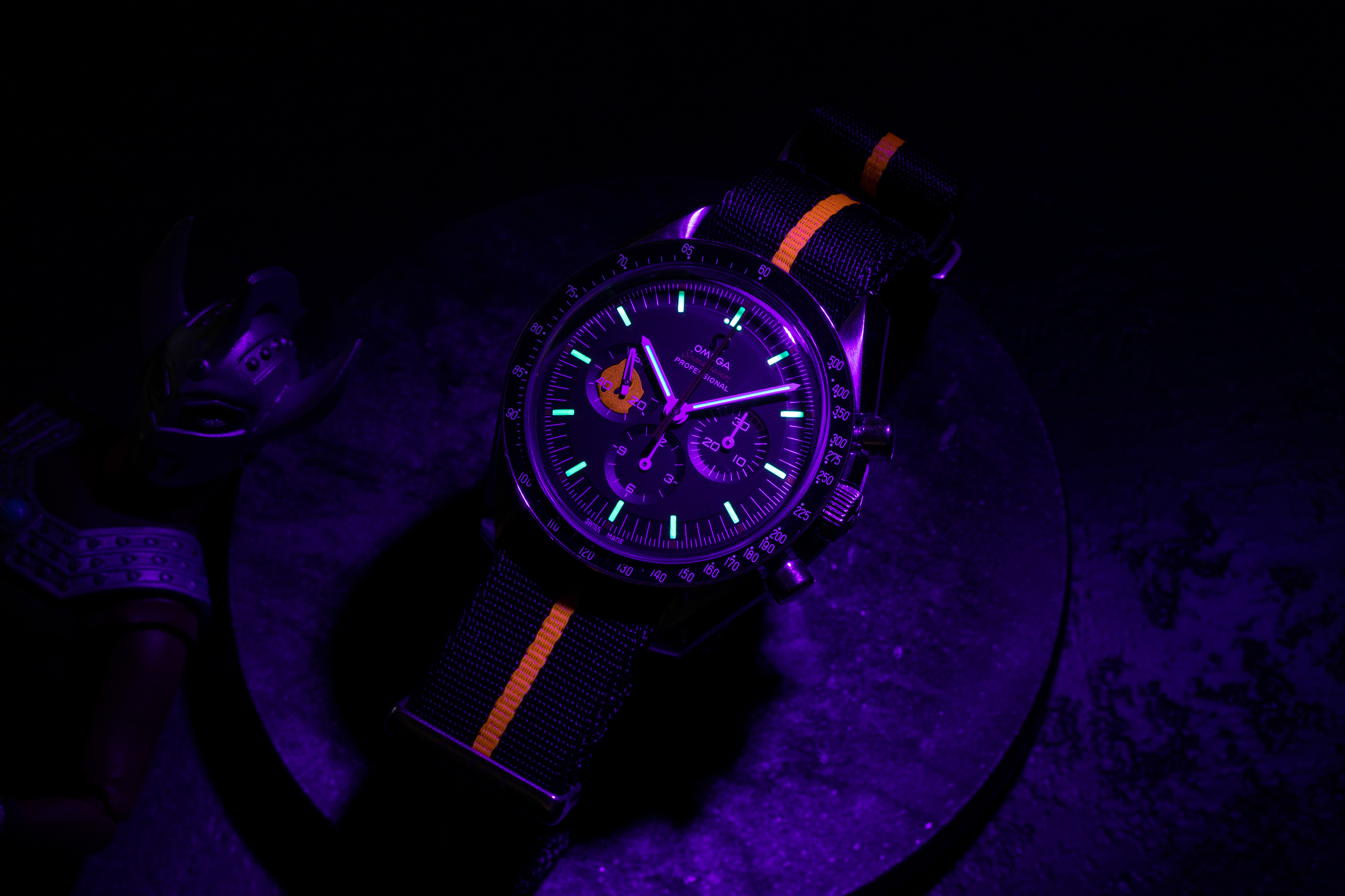 The hidden luminous Ultraman silhouette painted inside the continuous seconds marker can be seen only when a UV light used on the 2018 Speedmaster Limited Edition 42mm "Ultraman" , while in the dark