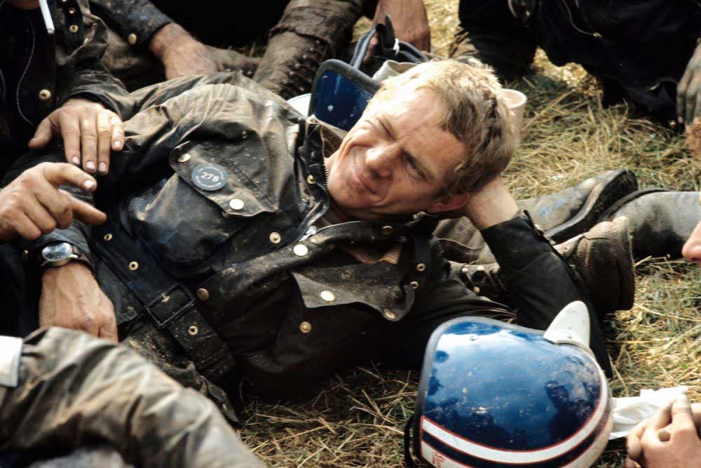 Steve McQueen resting after his run out on the 1964 ISDT track. On his wrist visible is the Hanhart 417 ES (Photo by Francois Gragnon / Paris Match via Getty Images)
