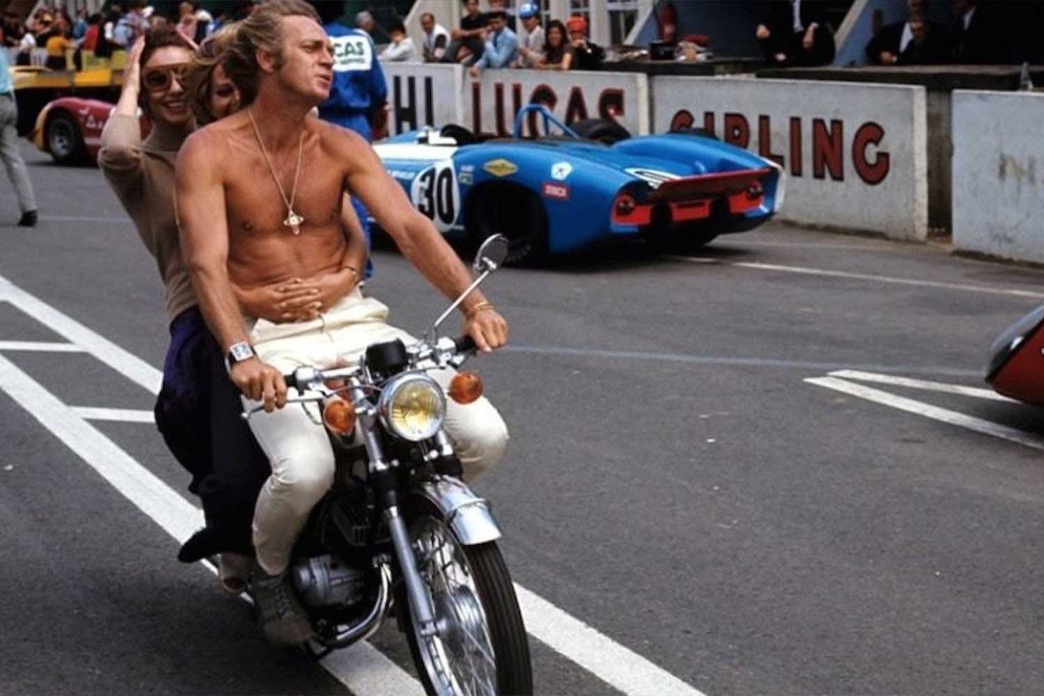 Steve McQueen out and about on the set of Le Mans on a motorbike, wearing the Heuer Monaco on his right wrist