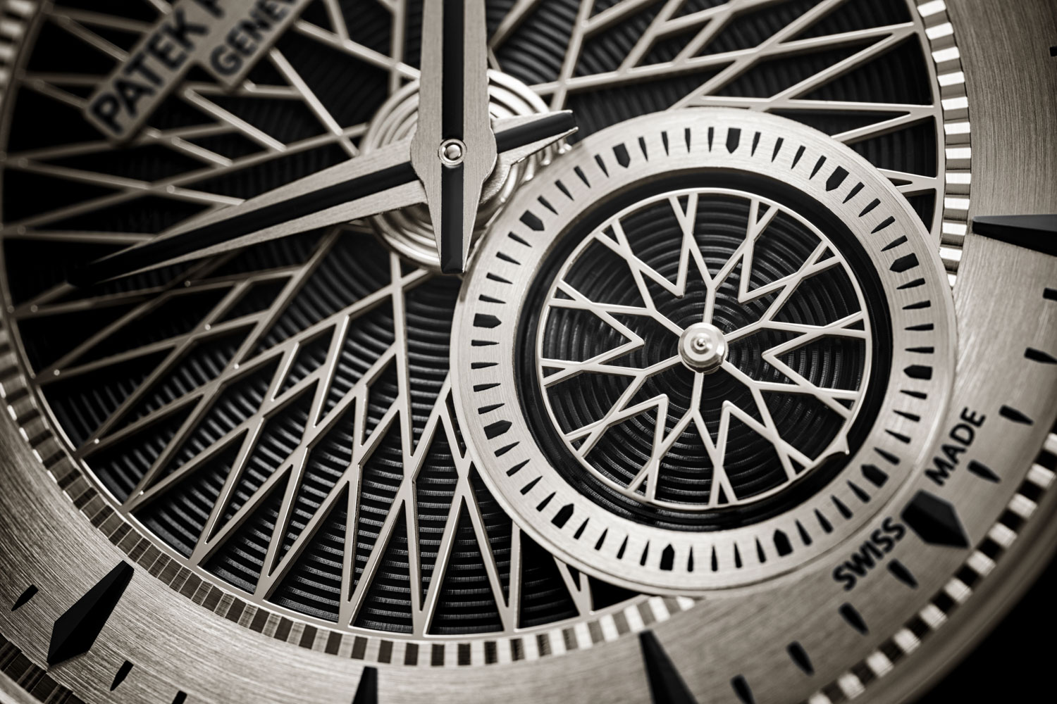 The 5750's dial consists of a five-part construction that starts with white gold, black nickel-plated snailed base with spiraling lines; on top of this is an openworked motif inspired by the spoked wheels of vintage automobiles; a similar rotating disc is used for the small seconds counter, which has a point on its outer edge serving as the seconds hand