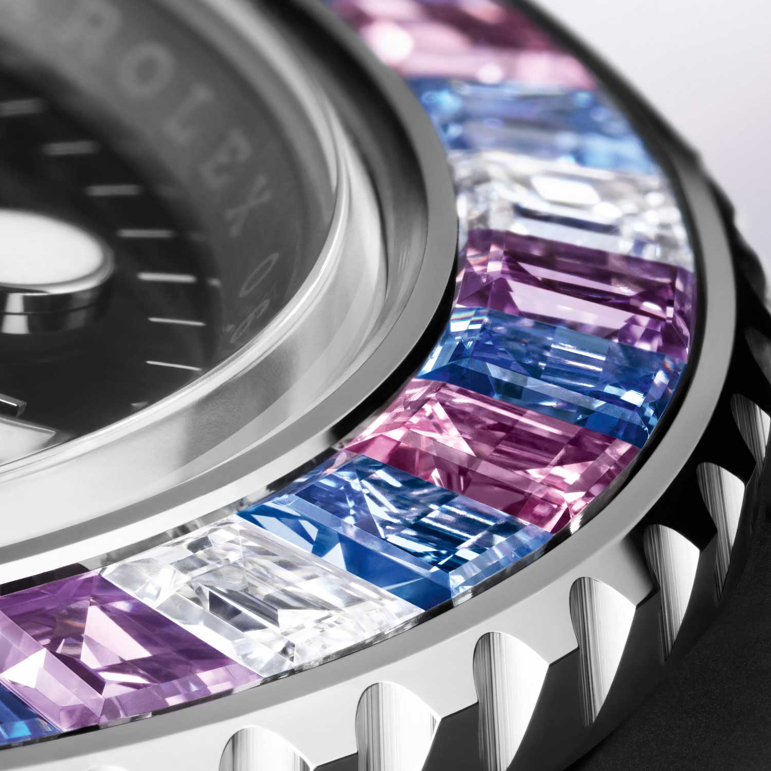 The 2022 Rolex Oyster Perpetual Yacht-Master 40 has a 18 ct white gold, bidirectional rotatable bezel set with 8 trapeze-cut diamonds (approx. 0.92 ct), 32 trapeze-cut sapphires (8 pink, 8 light blue, 8 purple and 8 dark blue) (approx. 4.27 ct) and one triangular diamond (approx. 0.15 ct) at 12 o’clock