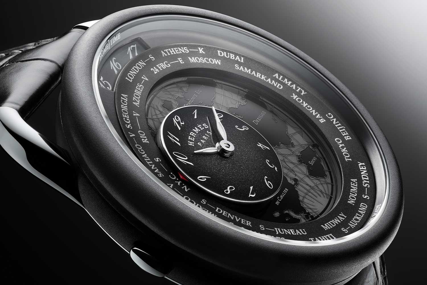 The subdial of the Hermès Arceau Le Temps Voyageur can be adjusted, using a pusher on the left side of the case, to make it move across the 24-cities listed to display your desired local time; home time is displayed using the aperture at 12 o'clock; home and local time must be synchronised first before local time can be displayed by using the crown on the right side (©JoelVonAllmen)