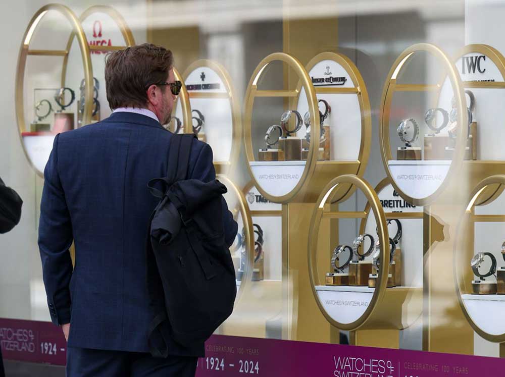 Shoppers look at watches in the window display of a Watches of Switzerland Group (Image: Hollie Adams/Bloomberg via Getty Images)
