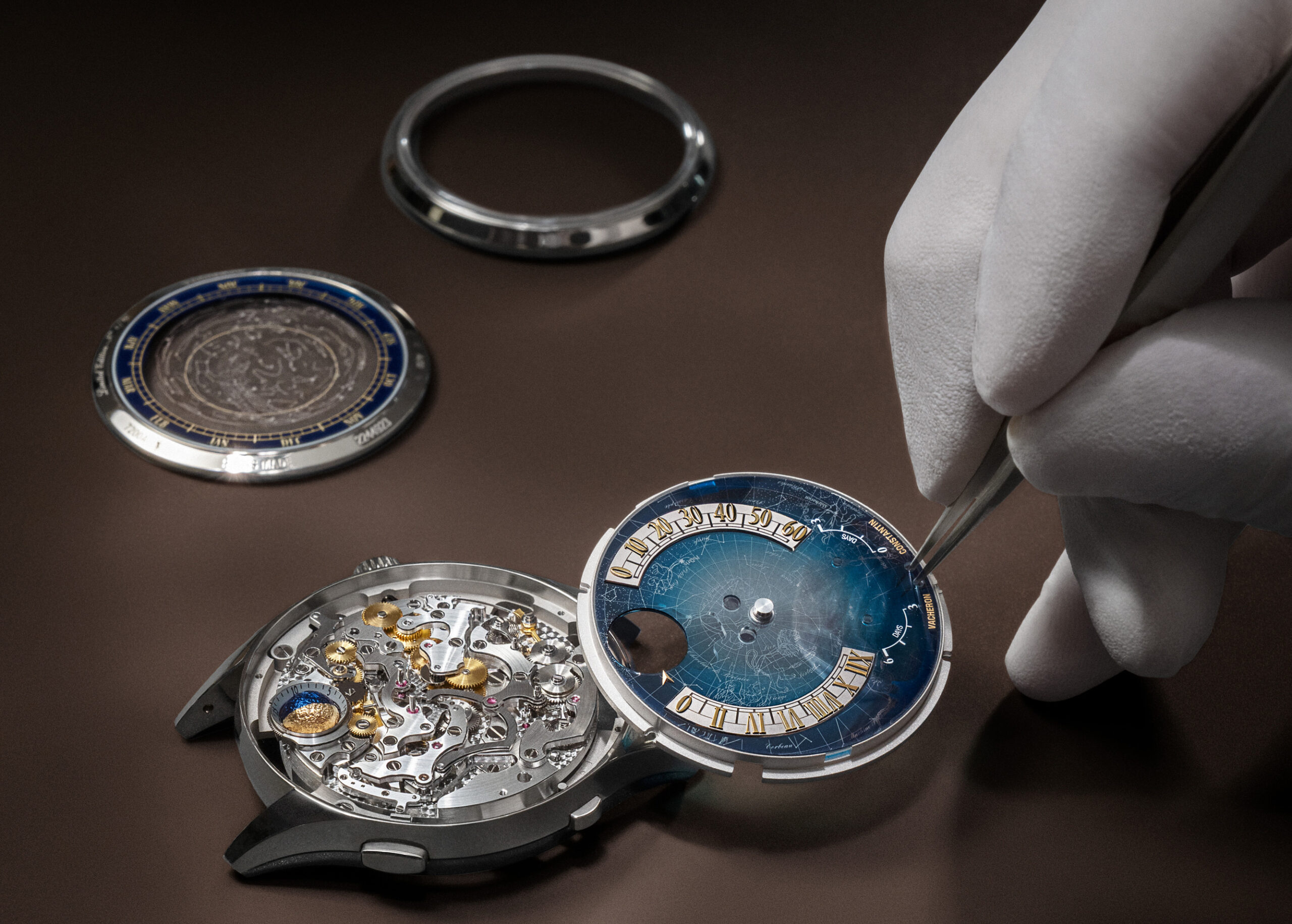 Watchmaker fitting sapphire dial layer depicting the 1755 Geneva night sky onto the Calibre 3670 movement during assembly.