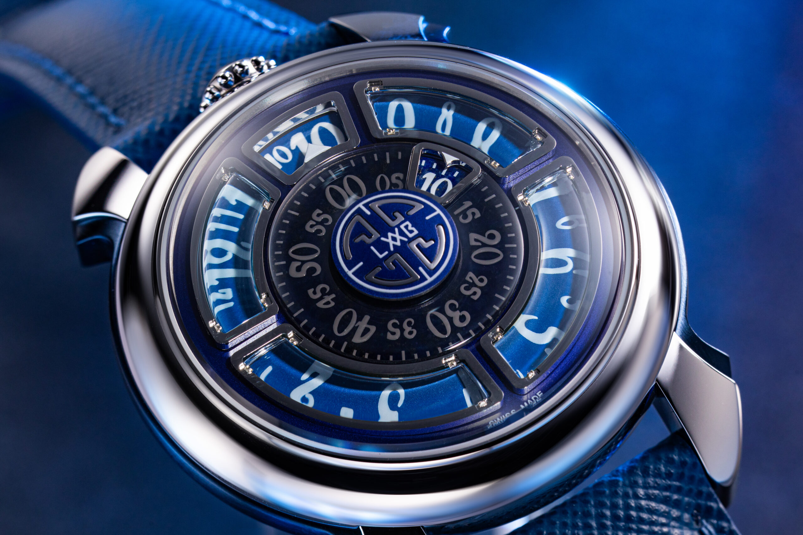 Close-up of Gagà Laboratorio Labormatic Luce watch dial with glowing blue numerals and central medallion.