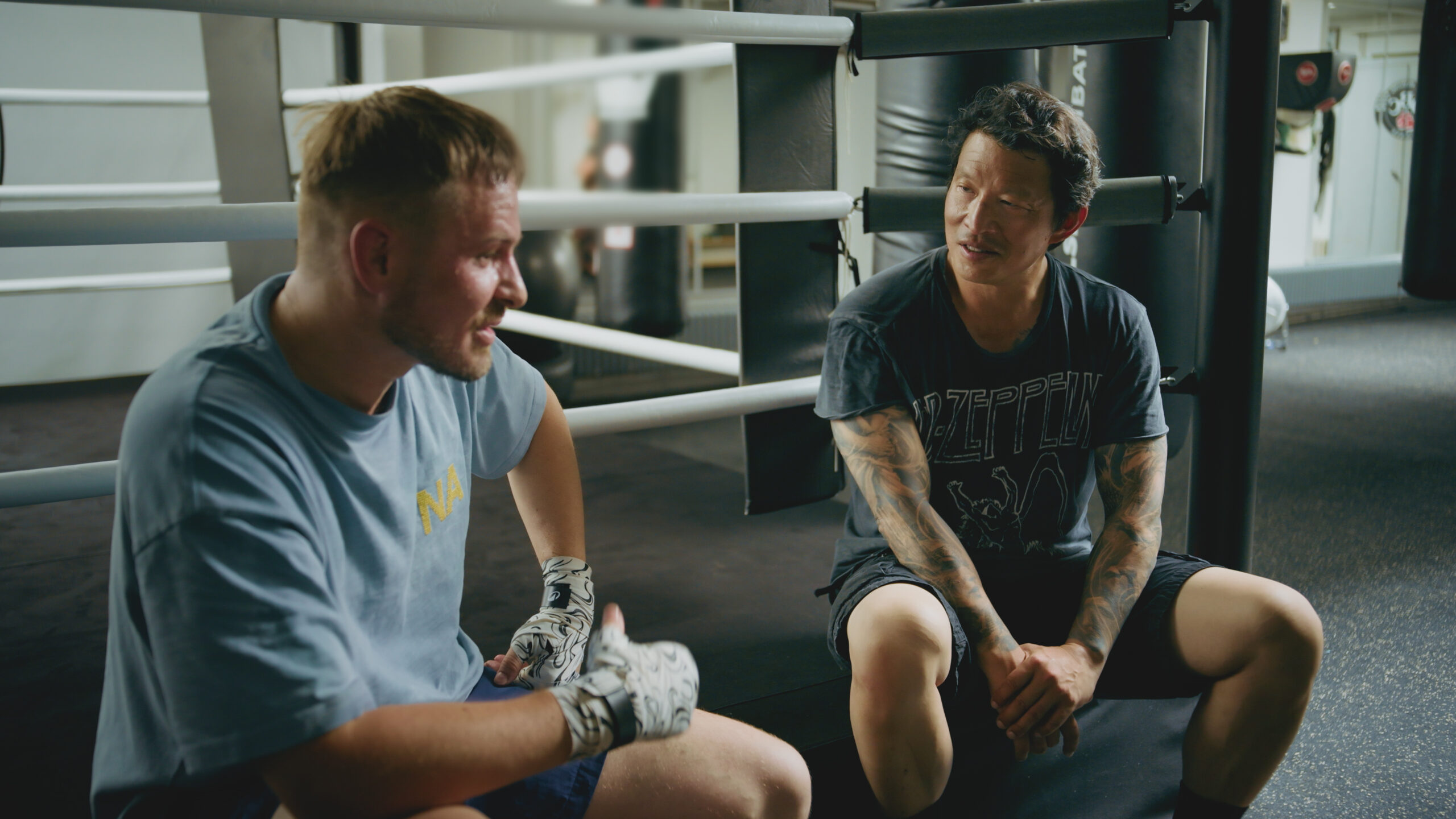 Wei Koh and Rexhep Rexhepi sitting in a boxing ring, talking after training during the Man of the Hour episode focused on Rexhepi’s Geneva atelier