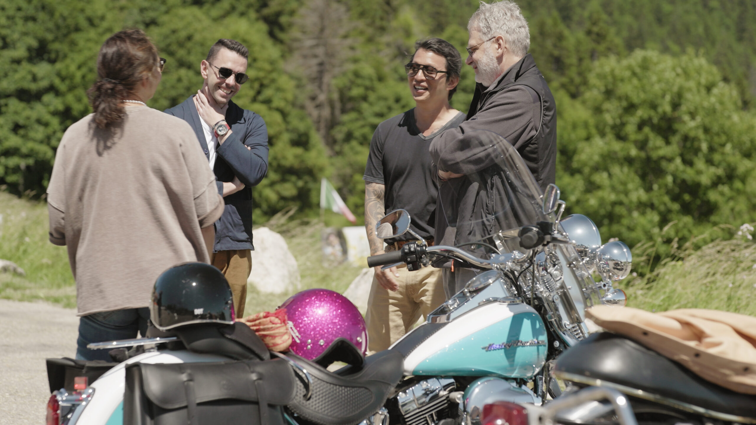 Sylva Greubel, Michel Nydegger, Wei Koh, and Robert Greubel standing together beside their motorcycles at the Vue des Alpes during filming of the Greubel Forsey episode of Man of the Hour