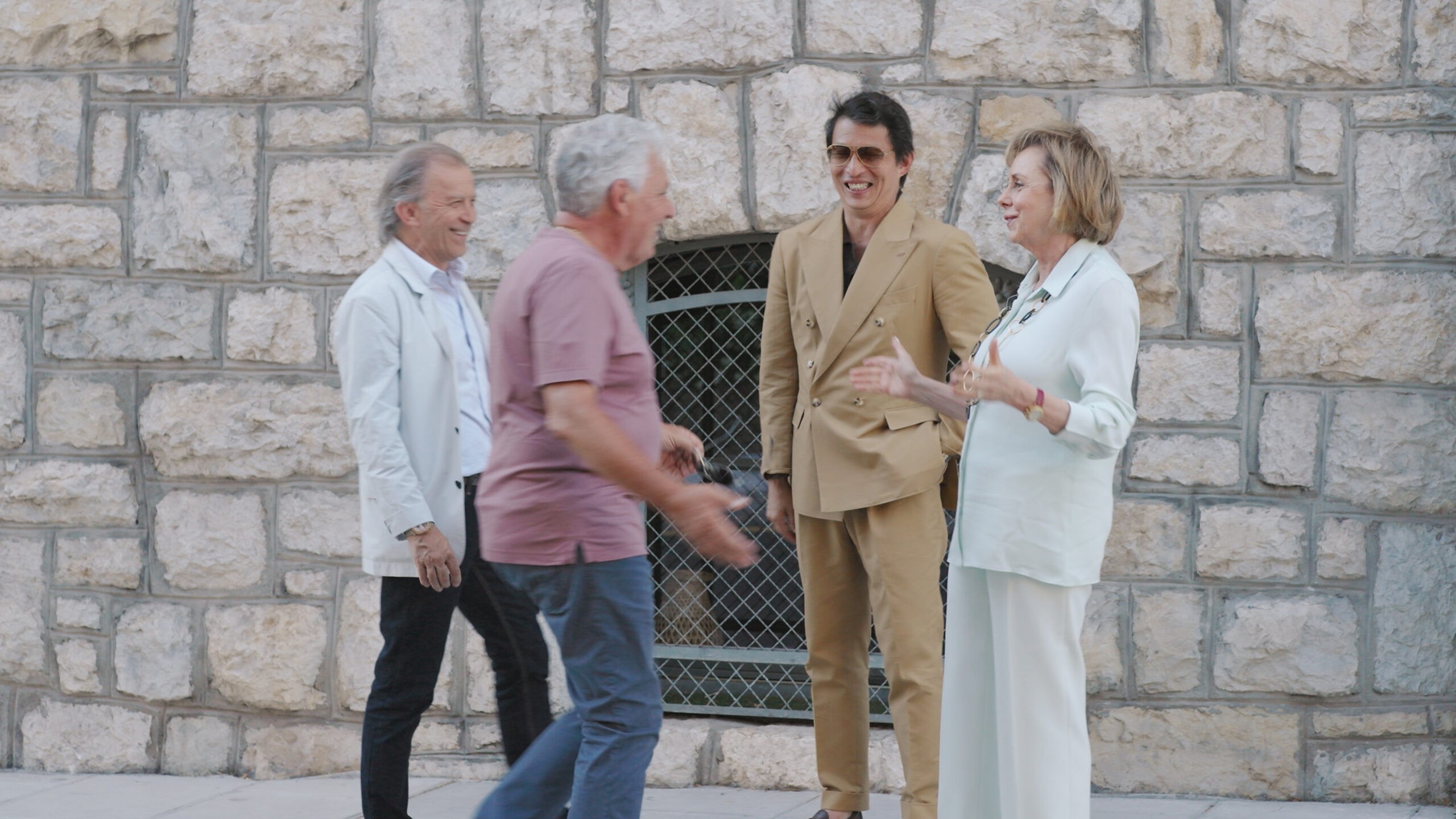 Michel Navas, Enrico Barbasini, Wei Koh, and Evelyne Genta standing together and sharing a laugh outside the original Gérald Genta manufacture, filmed for the Louis Vuitton episode of Man of the Hour