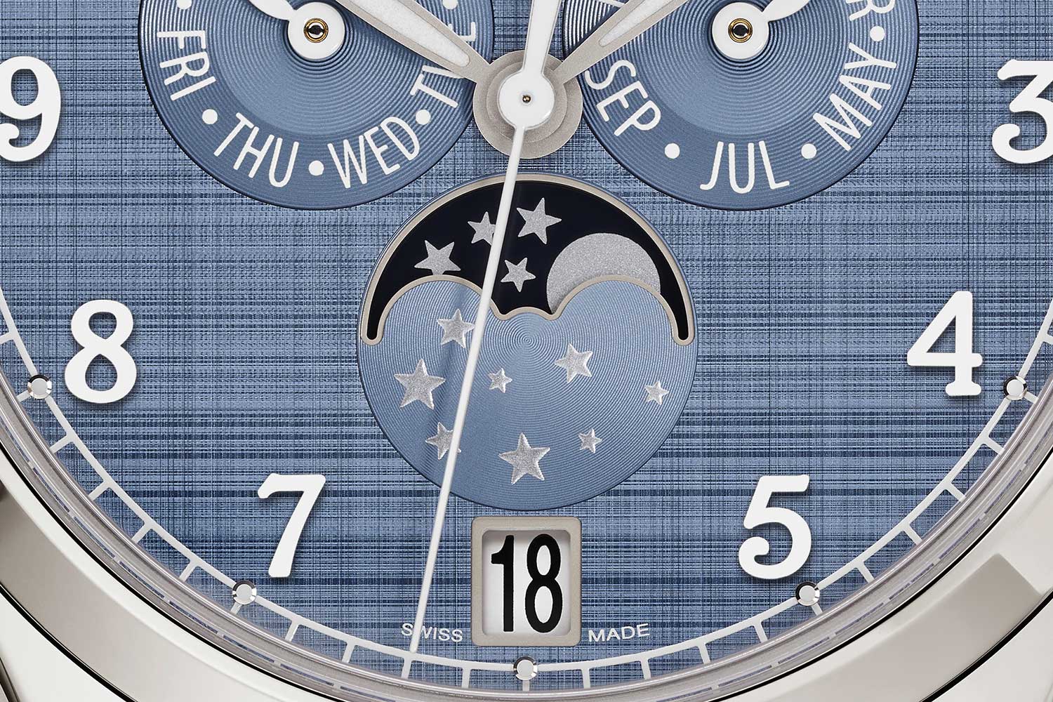 Close-up of Patek Philippe Ref. 4946G-001 showing blue-grey textured dial, moonphase, date window and day-month subdials